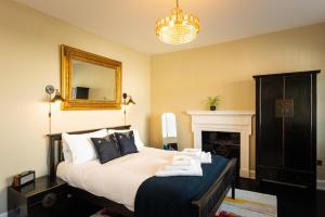 a bedroom with a bed with a mirror and a fireplace at Lyme 1 Hotel in Lyme Regis