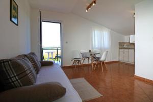 een woonkamer met een bank en een tafel met stoelen bij Apartmani i sobe Josica in Jezera