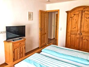 a bedroom with a bed and a flat screen tv at Ferienwohnungen Meyerlhof in Aschau im Chiemgau