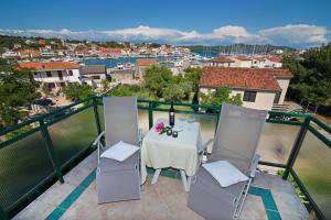 een tafel en stoelen op een balkon met uitzicht bij Apartmani i sobe Josica in Jezera