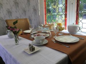 una mesa con mantel blanco y una mesa con platos y gafas en Manoir de L'Epine en Saint-Séverin