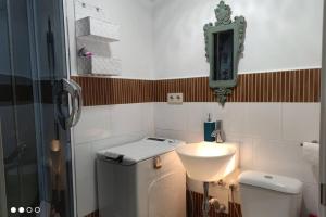 a small bathroom with a toilet and a sink at Apartamento Los Tulipanes in Lumpiaque