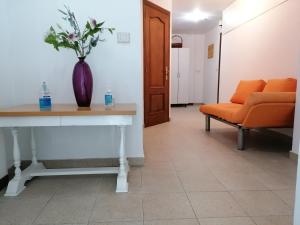 a hallway with orange chairs and a vase of flowers at Cuatro Caminos in Sarria