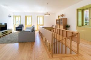 sala de estar con escalera, sofá y TV en Casa da Gueira, en Vale de Cambra