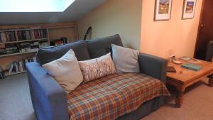 a blue couch with pillows in a living room at Invercassley Cottage B & B Suite in Lairg