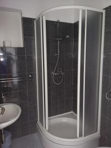 uma casa de banho com um chuveiro, um WC e um lavatório. em Apartments Martin em Primošten