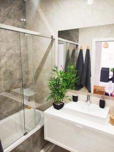 a bathroom with a white sink and a shower at Apartamento Rooftop Montenegro in Faro