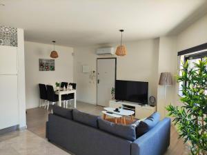 a living room with a blue couch and a tv at Apartamento Rooftop Montenegro in Faro +8 photos