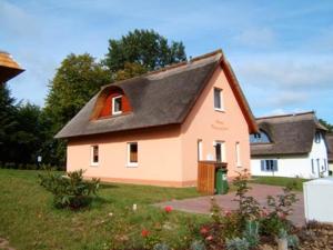 a small pink house with a black roof at Dwarslöper in Am Schwarzen Busch