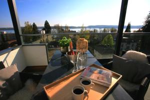 einen Tisch auf einem Balkon mit zwei Tassen Kaffee in der Unterkunft Überlinger See-Apartments Penthouse Über-See in Überlingen