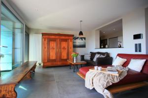 ein Wohnzimmer mit einem roten Sofa und einem Tisch in der Unterkunft Überlinger See-Apartments Penthouse Über-See in Überlingen