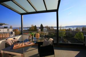 ein Esszimmer mit Tisch und Stühlen und einem großen Fenster in der Unterkunft Überlinger See-Apartments Penthouse Über-See in Überlingen