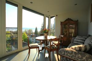 ein Wohnzimmer mit Tisch und großem Fenster in der Unterkunft Überlinger See-Apartments Penthouse Über-See in Überlingen