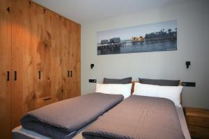 ein Schlafzimmer mit zwei Betten und einem Holzschrank in der Unterkunft Überlinger See-Apartments Penthouse Über-See in Überlingen