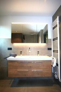 ein Badezimmer mit Waschbecken und Spiegel in der Unterkunft Überlinger See-Apartments Penthouse Über-See in Überlingen + 18 Fotos