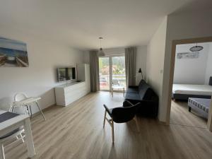 a living room with a couch and a bed at Apartamenty PRZY MORZU Pobierowo in Pobierowo
