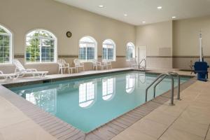 a large swimming pool in a building with chairs at Country Inn & Suites by Radisson, Baltimore North, MD in White Marsh