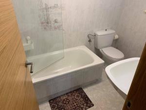 a bathroom with a tub and a toilet and a sink at Apartamento MARIÑA SANXENXO in Sanxenxo