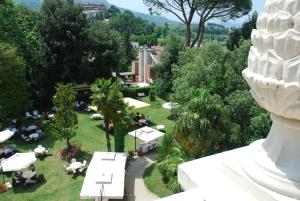 una vista sul parco con tavoli e alberi di Hotel Villa Pigna ad Ascoli Piceno
