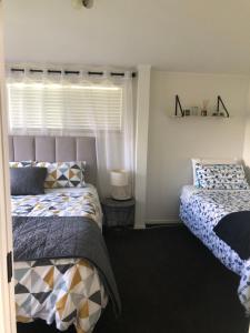 a bedroom with two beds and a window at Hills Vista Lodge in Matamata