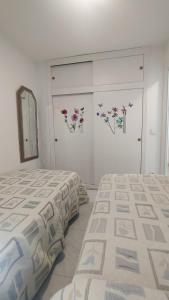 1 Schlafzimmer mit 2 Betten und einem Wandspiegel in der Unterkunft BENIDORM, Las Damas, primera línea de playa de Levante in Benidorm