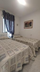 ein Zimmer mit drei Betten in einem Zimmer in der Unterkunft BENIDORM, Las Damas, primera línea de playa de Levante in Benidorm + 4 Fotos