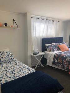 1 Schlafzimmer mit 2 Betten und einem Fenster in der Unterkunft Hills Vista Lodge in Matamata
