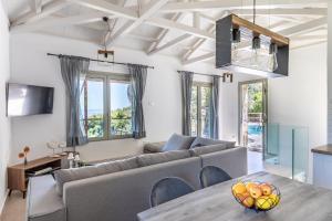 a living room with a couch and a table at Petrino Villas in Skopelos Town