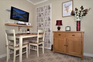 una sala da pranzo con tavolo, sedie e TV di The Bridge Suite a Invermoriston