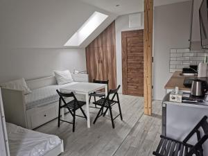 a room with a table and chairs and a kitchen at Pokoje pod Baranami Zator Przeciszów in Przeciszów