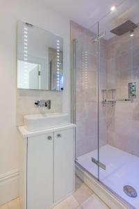 a white bathroom with a sink and a shower at Lovely 1-Bed Apartment in London in London