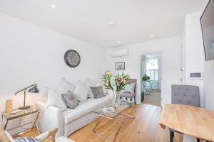 a living room with a white couch and a table at Lovely 1-Bed Apartment in London in London