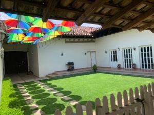 a patio with a lawn with umbrellas hanging from it at CASA SÁNCHEZ in Zacatlán