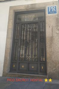 eine Tür eines Gebäudes mit einem schmiedeeisernen Tor in der Unterkunft PICO SACRO I HOSTAL-PENSION Santiago de Compostela in Santiago de Compostela