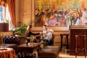 Un uomo e una donna seduti a un tavolo in un ristorante di Hotel & Spa Saint-Jacques a Parigi