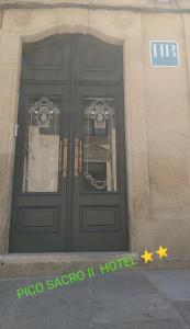 un par de puertas en un edificio con una señal en PICO SACRO II HOTEL Santiago de Compostela en Santiago de Compostela