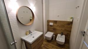 a bathroom with a sink and a toilet and a mirror at Apartament Parkowy Studio in Gniezno