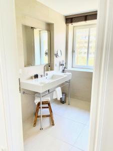 Baño blanco con lavabo y espejo en Villa Wattfuss, en Sankt Peter-Ording