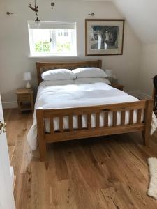 a large bed in a bedroom with a wooden floor at Lane End Cottage in Ovington