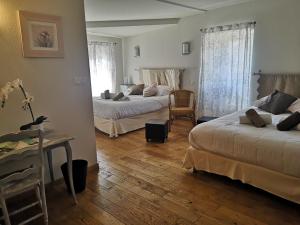 1 dormitorio con 2 camas, mesa y escritorio en Auberge de l Helvie chez Coco & Ricou, en Valvignères