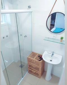 Un baño con lavabo y ducha de cristal. en Solar Di Petrópolis - Apartamentos de Temporada, en Nova Petrópolis
