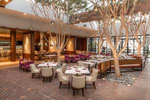 een restaurant met tafels, stoelen en bomen bij Portola Hotel & Spa in Monterey