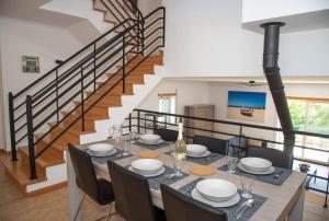 een eetkamer met een tafel en stoelen en een trap bij Casa Gemeos in Alcobaça