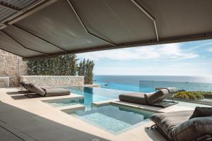 a swimming pool with a view of the ocean at THE WAVE GRANDE VILLA KATHISMA Lefkada in Lefkada