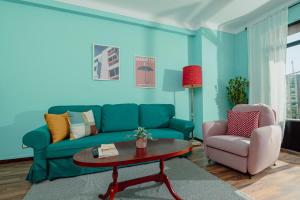 ein Wohnzimmer mit einem blauen Sofa, einem Tisch und einem Stuhl in der Unterkunft Appartements - Centre Ville in Rabat