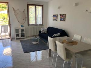 Riomaggiore Apartment cà di Euro في ريوماجّوري: غرفة معيشة مع أريكة زرقاء وطاولة