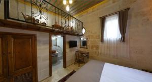 a bedroom with a bed and a balcony and a bathroom at Zuwinasa House Hotel in Avanos