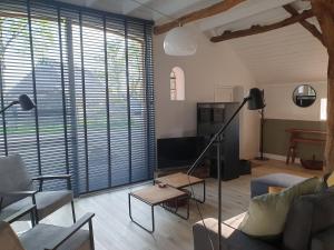 a living room with a couch and a tv at Ermerhoek: op de Deel in Erm