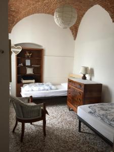 1 dormitorio con 2 camas, silla y cómoda en Casa Maria, en Cervo