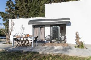 eine Terrasse mit Stühlen und einem Tisch vor einem Gebäude in der Unterkunft Olive View Loft in Dhíkella
